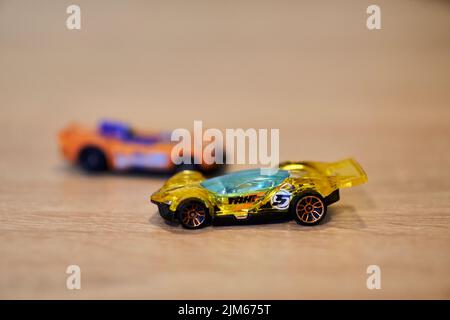 Eine Nahaufnahme von Mattel Hot Wheels Spielzeugautos auf einer Holzoberfläche. Stockfoto