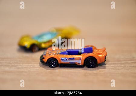 Eine Nahaufnahme von Mattel Hot Wheels Spielzeugautos auf einer Holzoberfläche. Stockfoto