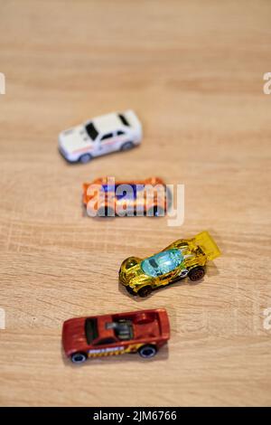 Eine vertikale Nahaufnahme von Mattel Hot Wheels Spielzeugmodellen auf einer Holzoberfläche. Stockfoto