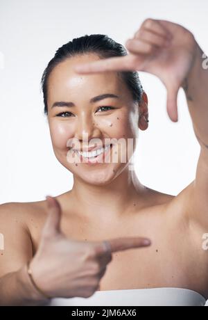 Das nächste Mal, wenn Sie an schöne Dinge denken, vergessen Sie nicht, sich selbst einzubeziehen. Eine schöne junge Frau posiert vor einem weißen Hintergrund. Stockfoto
