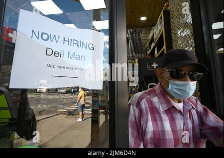 New York, USA. 03. August 2022. Am Fenster eines lokalen Delikatessengeschäfts im New Yorker Stadtteil Queens, NY, wird am 4. August 2022 ein Einstellungssingen aufgezeichnet. Es wird erwartet, dass am Ende der Woche neue Beschäftigungszahlen bekannt gegeben werden. Die US-Wirtschaft dürfte weniger Arbeitsplätze gewonnen haben als in den vergangenen Monaten, von 450.000 auf 250.000 Arbeitsplätze. (Foto von Anthony Behar/Sipa USA) Quelle: SIPA USA/Alamy Live News Stockfoto