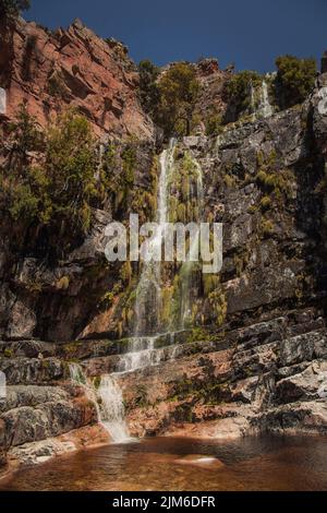 Ein kleiner Wasserfall auf einem felsigen Berg Stockfoto