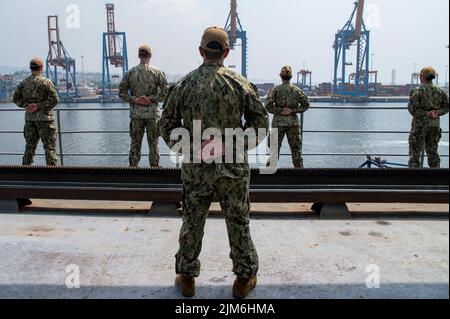 VISAKHAPATNAM, Indien (Aug 1, 2022) – Seeleute, die dem Emory S Land-Klasse-U-Boot-Tender USS Frank Cable (AS 40) zugewiesen wurden, fahren auf den Schienen, während das Schiff in Visakhapatnam, Indien, am 1. August 2022 pierseitig festmacht. Frank Cable ist derzeit auf Patrouille und führt Expeditions- und Logistikarbeiten im 7.-Flottenbereich durch, um einen freien und offenen Indo-Pacific zu unterstützen. (USA Navy Foto von Mass Communication Specialist 1. Class Charlotte C. Oliver) Stockfoto