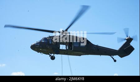 Der Abseilmeister mit der Hauptquartier- und Hauptquartier-Kompanie, 1. Bataillon, 110. Infanterie-Regiment, 2. Infanterie-Brigade-Kampfteam, überprüft die Linien, bevor die Soldaten während des Abseiltrainings in Fort Indiantown Gap, Pennsylvania, am 3. August 2022 einhaken und abseilen. Der Abseilmeister arbeitet mit Piloten und Besatzung des UH-60 Black Hawk zusammen, um die zu Boden abseilenden Soldaten besser zu unterstützen und zu koordinieren (Foto der US-Armee von Sgt. 1. Klasse Matthew Keeler) Stockfoto