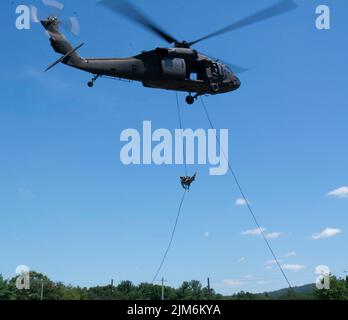 Ein Soldat der Hauptquartier- und Hauptquartier-Kompanie, 1. Bataillon, 110. Infanterie-Regiment, 2. Infanterie-Brigade-Kampfteam, rappelt am 3. August 2022 von einem schwarzen Falken der UH-60 während des Abseiltrainings in Fort Indiantown Gap, Pennsylvania, ab. Die Soldaten der 1-110. arbeiteten mit den Piloten und Besatzungen der Expeditionary Combat Aviation Brigade 28. zusammen, um sich vom schwarzen Falken abzuseilen (Foto der US-Armee von Sgt. 1. Klasse Matthew Keeler) Stockfoto