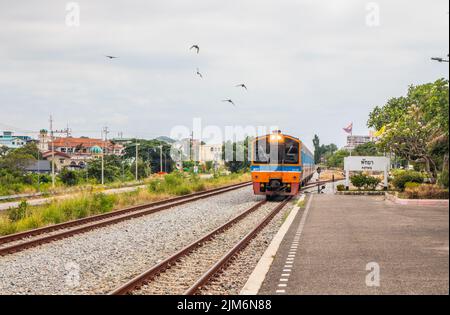 Ein Zug fährt in einen Bahnhof und wartet in Thailand auf Fahrgäste Stockfoto
