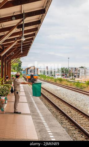 Ein Zug fährt in einen Bahnhof und wartet in Thailand auf Fahrgäste Stockfoto