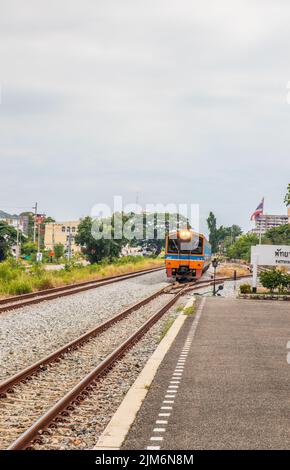 Ein Zug fährt in einen Bahnhof und wartet in Thailand auf Fahrgäste Stockfoto