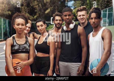 Basketballspieler von Natur aus. Porträt einer Gruppe sportlicher junger Menschen, die auf einem Sportplatz zusammenstehen. Stockfoto