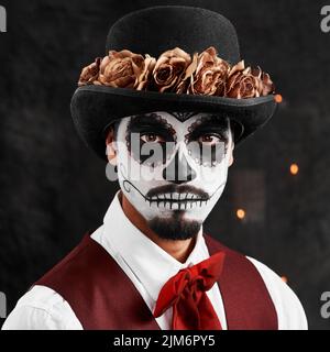 Dia de los Muertos. Das verkürzte Porträt eines hübschen jungen Mannes, der in seinem Halloween-Kostüm im mexikanischen Stil gekleidet ist. Stockfoto