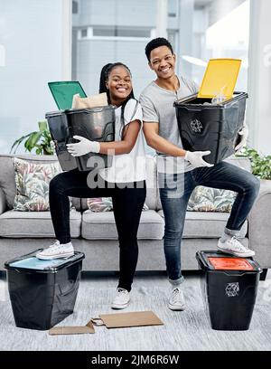 Verschwenden Sie es nicht, sparen Sie es. Ein junges Paar recycelt ihren Müll zu Hause. Stockfoto