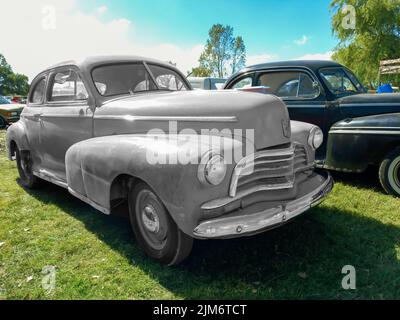 Chascomus, Argentinien - 09. Apr 2022: Altes rostrotes Chevrolet Chevy Fleetmaster Sportcoupé 1946 von GM auf dem Rasen geparkt. Oldtimer-Show. Stockfoto