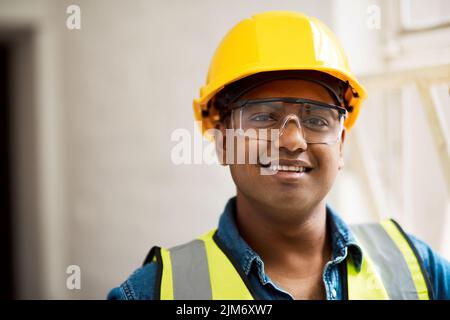 Bauarbeiten erfordern eine angemessene Sicherheitsausrüstung. Ein Ingenieur, der Schutzkleidung auf einer Baustelle trägt. Stockfoto