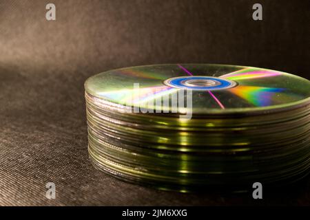 Einige Compact Disk, DVDs, die auf einer schwarzen Oberfläche gestapelt sind Stockfoto