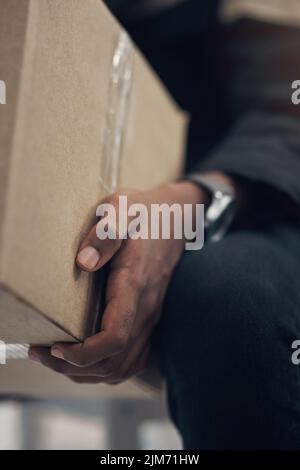 Wie immer pünktlich. Ein Mann, der ein Paket an einen Wohnort liefert. Stockfoto