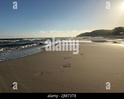 Eine schöne Aufnahme eines Strandes an der Ostsee mit Fußabdrücken auf dem Sand in Pommern, Deutschland Stockfoto