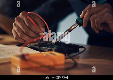 Hochwertige Verarbeitung für hochwertige Ergebnisse. Ein Techniker mit einem Lötkolben. Computer-Hardware zu reparieren. Stockfoto