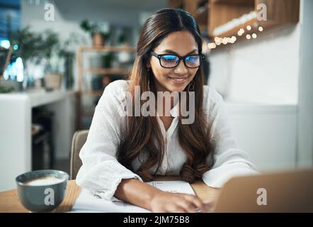 Ich habe viel von dem gelernt, was ich aus Blogs kenne. Eine Geschäftsfrau, die ihren Laptop benutzt, während sie in einem Café arbeitete. Stockfoto