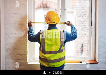 Genauigkeit ist wichtig, um sicherzustellen, dass ein Projekt reibungslos läuft. Ein Ingenieur, der Messungen auf einer Baustelle macht. Stockfoto