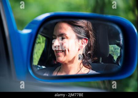 Spiegelung der reifen schönen Frau im seitlichen Rückspiegel Stockfoto