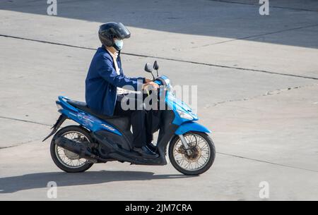 SAMUT PRAKAN, THAILAND, MAI 30 2022, Ein Mann mit Helm fährt ein Motorrad auf der sonnigen Straße Stockfoto