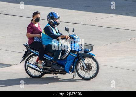 SAMUT PRAKAN, THAILAND, MAI 30 2022, Ein Taxifahrer auf einem Motorrad fährt mit einer Frau. Stockfoto