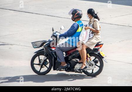 SAMUT PRAKAN, THAILAND, MAI 30 2022, Ein Taxifahrer auf einem Motorrad fährt mit einer Frau. Stockfoto