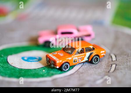 Ein selektiver Fokus auf eine Mischung aus Mattel Hot Wheels Spielzeugmodellen auf einer Spielmatte Stockfoto