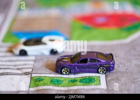 Nahaufnahme einer Mischung aus Mattel Hot Wheels Spielzeugmodellen auf einer Spielmatte Stockfoto