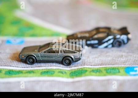 Ein selektiver Fokus auf eine Mischung aus Mattel Hot Wheels Spielzeugmodell schwarzes Auto auf einer Spielmatte Stockfoto