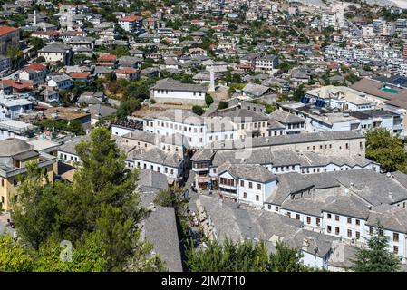 Gjirokaster, Albanien - 10. September 2022: Straßenansicht der Innenstadt von oben bei Tag mit Dächern und Menschen auf den Straßen in Gjirokaster, einem UNESCO-Weltkulturerbe Stockfoto