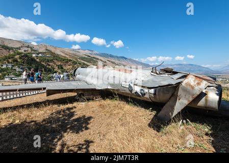 Gjirokaster, Albanien - 10. September 2022: Touristen in der Nähe des amerikanischen Jagdsternflugzeugs Lockheed T-33, ausgestellt im Waffenmuseum in Gjirokastra Stockfoto