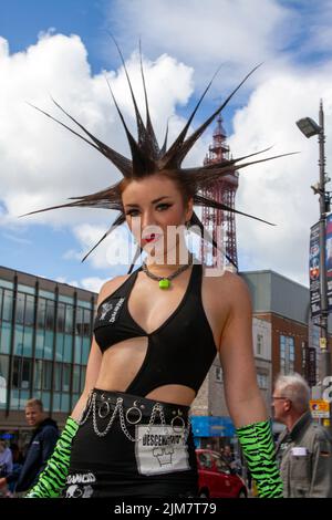 Amerikanisches Model, sag-AFTRA Schauspielerin, Garderobe Stylistin, TV-Moderatorin. Modedesignerin, mit mohikanischem Stil, gefärbten Haaren und Farbstoffen beim Punk Rebellion Festival in den Winter Gardens. Ein Protest gegen konventionelle Einstellungen und Verhaltensweisen, ein Zusammenprall von Anti-Establishment-Kulturen, Mohawks, Sicherheitsnadeln und eine Menge Haltung in der Küstenstadt, da Punks, die das jährliche Rebellion Rock Music Festival in den Wintergärten besuchen, mit traditionellen Urlaubern Seite an Seite stehen. Stockfoto