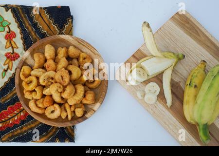 Eine Draufsicht auf gebratene Garnelen und kleine Bananen auf einem Schneidebrett Stockfoto