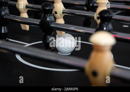 Nahaufnahme eines Tischfußballspiels für Kinder mit Spielern und einem Ball. Stockfoto