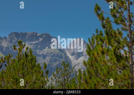 Blick auf die Hänge verschiedener Berggipfel rund um das Valbona-Tal im Norden Albaniens, mit Bäumen, Tannen und felsigen Berglandschaften. Stockfoto