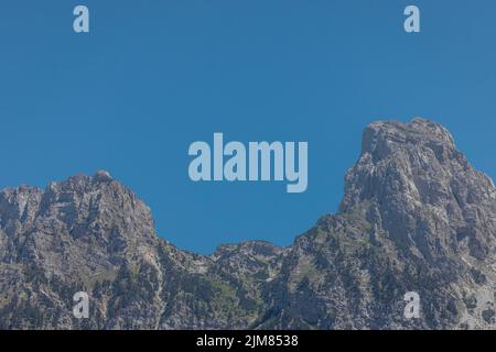 Blick auf die Hänge verschiedener Berggipfel rund um das Valbona-Tal im Norden Albaniens, mit Bäumen, Tannen und felsigen Berglandschaften. Stockfoto