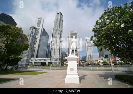 Weißes Marmordenkmal von Sir Stamford Rafales, dem Gründer des modernen Singapur, an der historischen Landeplatz mit dem CBD auf der anderen Flussseite Stockfoto