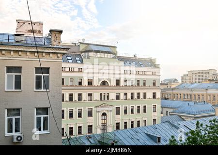 Blick auf benachbarte Häuser und das Stadtleben aus einem offenen Fenster. Stockfoto