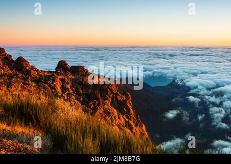 Berglandschaft über Wolken bei Sonnenaufgang Stockfoto