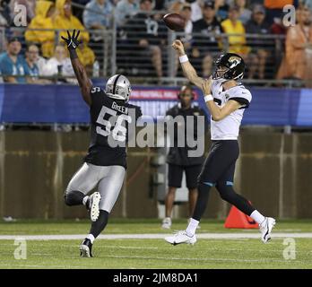 Canton, Vereinigte Staaten. 04. August 2022. Jacksonville Jaguars Jake Luton (6) wirft am Donnerstag, den 4. August 2022, in der ersten Hälfte der Pro Football Hall of Game in Canton, Ohio, unter Druck der Las Vegas Raiders Gerri Green (56). Foto von Aaron Josefczyk/UPI Credit: UPI/Alamy Live News Stockfoto