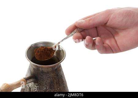 Der Löffel gemahlenen Kaffees fiel in eine Kaffeemaschine Stockfoto