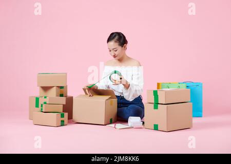 Start up Kleinunternehmen Unternehmer KMU freiberufliche asiatische Frau arbeiten mit Box zu Hause Stockfoto