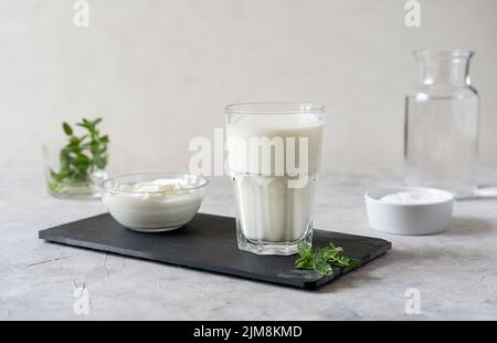 Ayran oder Doogh ist ein beliebtes erfrischendes Getränk aus dem Nahen Osten, das aus Joghurt, Wasser und Salz hergestellt wird. Konkreter Hintergrund Stockfoto