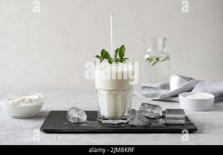 Ayran oder Doogh ist ein beliebtes erfrischendes Getränk aus dem Nahen Osten, das aus Joghurt, Wasser und Salz hergestellt wird. Konkreter Hintergrund Stockfoto