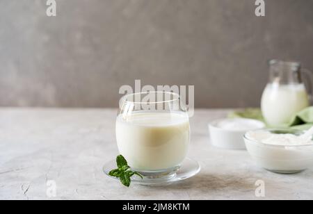 Ayran ist ein beliebtes erfrischendes Getränk aus dem Nahen Osten, das mit Joghurt, Wasser und Salz hergestellt wird. Konkreter Hintergrund Stockfoto