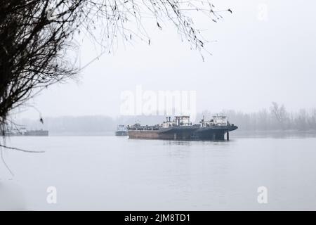 Tanker auf der Donau während der Winterzeit. Im Winter verankerte Tanker auf der Donau. Stockfoto