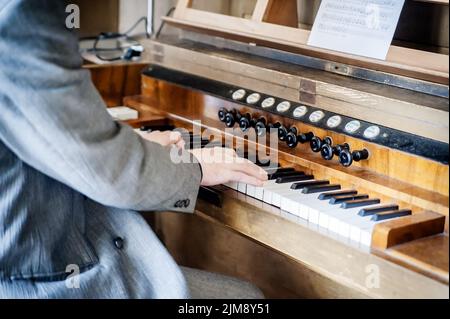 Mann spielt eine Pfeifenorgel Stockfoto