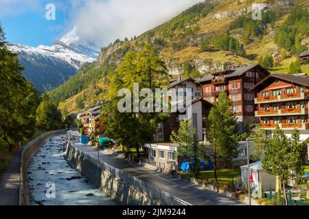 Zermatt, Schweiz - 7. Oktober 2019: Blick auf die Straße der Stadt im berühmten Skigebiet Schweizer Alpen, Fluss, Matterhorn Schneegipfel Stockfoto