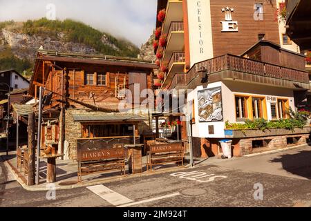 Zermatt, Schweiz - 7. Oktober 2019: Blick auf die Stadt im berühmten schweizer Skigebiet, bunte traditionelle Häuser, Berge Stockfoto